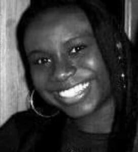 A black and white photo of a woman smiling.