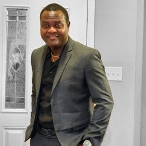 A man in a suit standing next to a door.